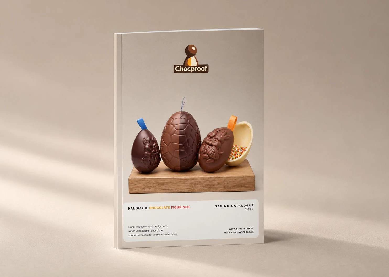 Chocproof Spring 2027 catalogue standing upright on a beige studio background